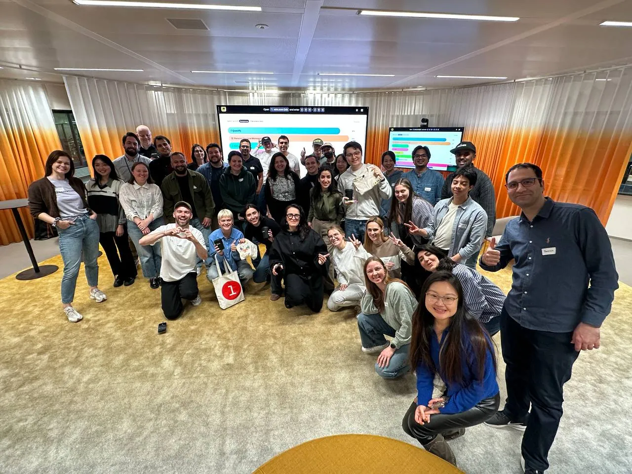 Participants from the Miro × Lovable Buildathon gathered in front of collaboration screens in Amsterdam.