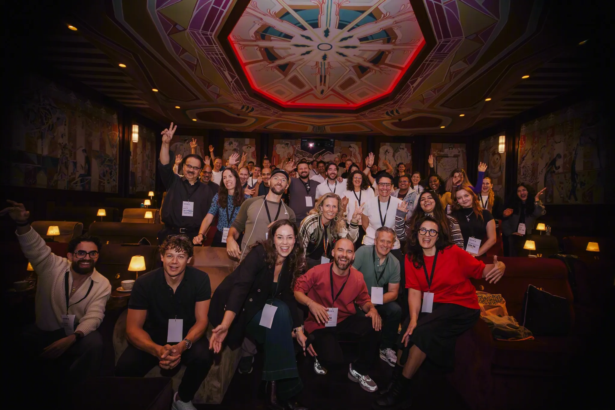 Speakers, organisers and attendees of VibeConf 2026 together in the hall at Pathé Tuschinski, many waving at the camera.